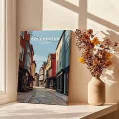 Colchester travel poster canvas print on sunny window sill beside vase with dried flowers