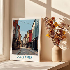 Colchester travel poster canvas print on a sunny windowsill with vase of dried flowers