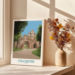 Colchester England travel poster canvas on windowsill with autumn flowers in vase and sunlight