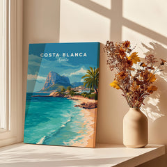 Costa Blanca Spain Travel Art – Mediterranean Village & Turquoise Sea Landscape Poster displayed near flowers.