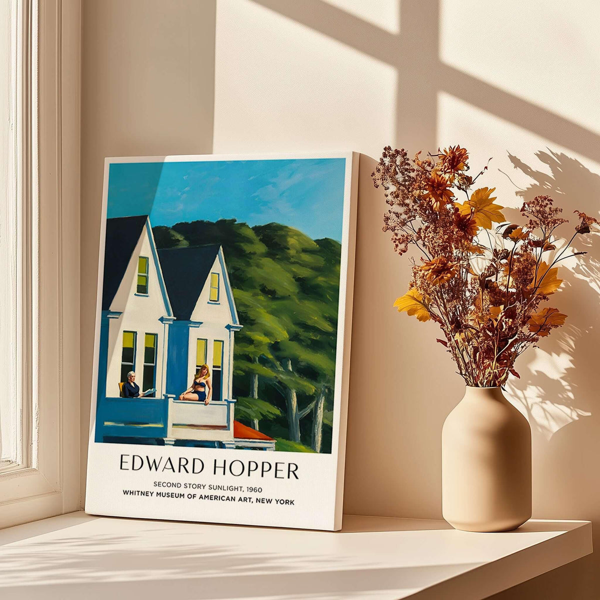 Edward Hopper Second Story Sunlight 1960 Art Print - Whitney Museum displayed on a table next to a vase with dried flowers.