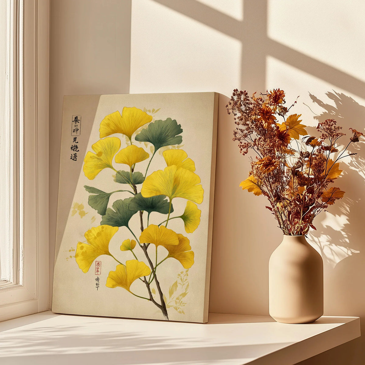 Ginkgo leaf wall art print beside vase with dried flowers on sunlit window ledge