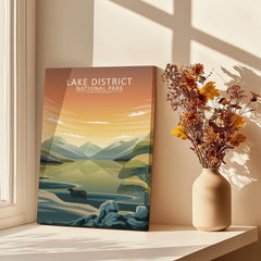 Lake District National Park art print with mountains and lake, on a windowsill beside a vase of dried flowers