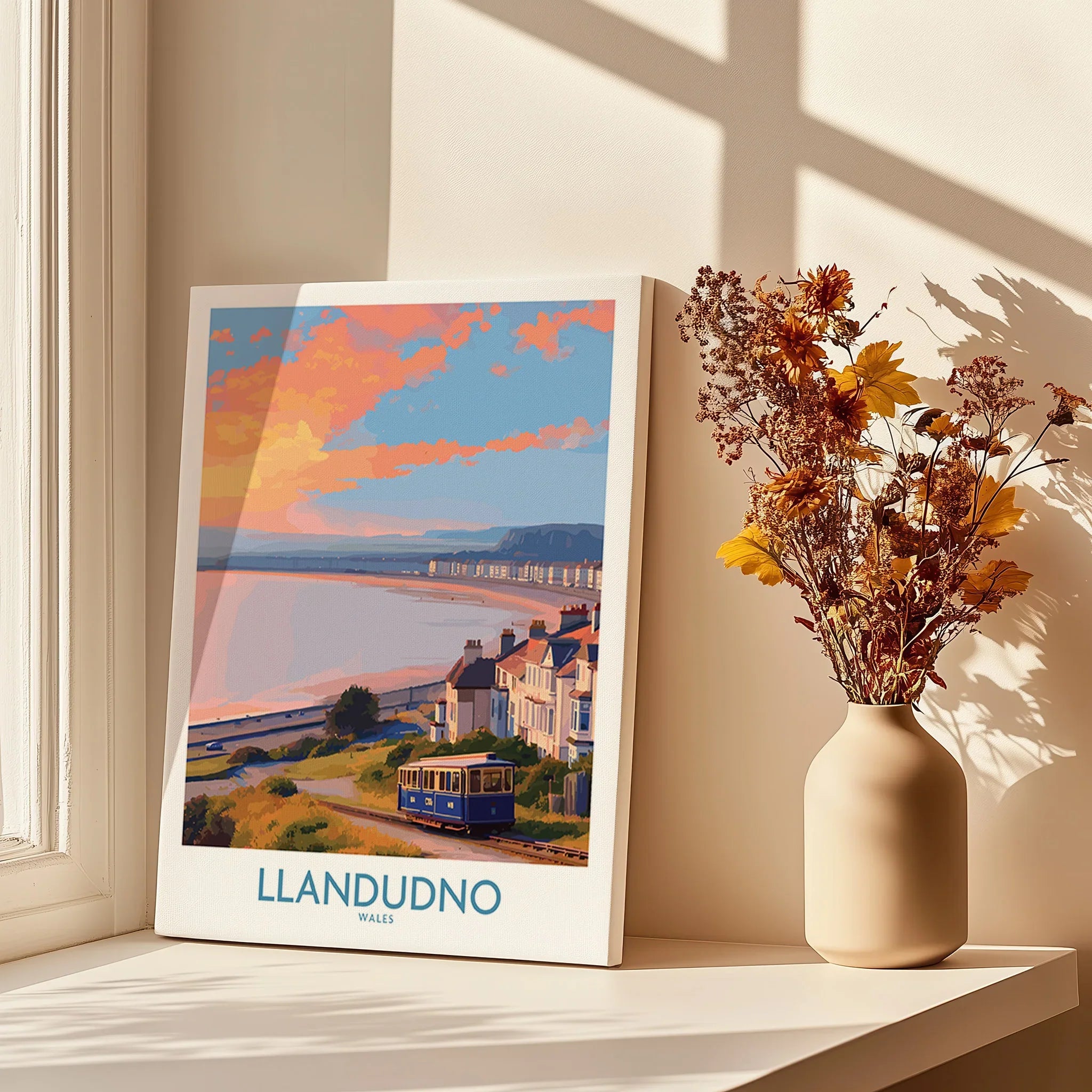 Llandudno travel poster canvas print on windowsill with shadows and dried flowers in vase