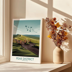 Peak District National Park art print on canvas by a window, with vase of dried flowers.
