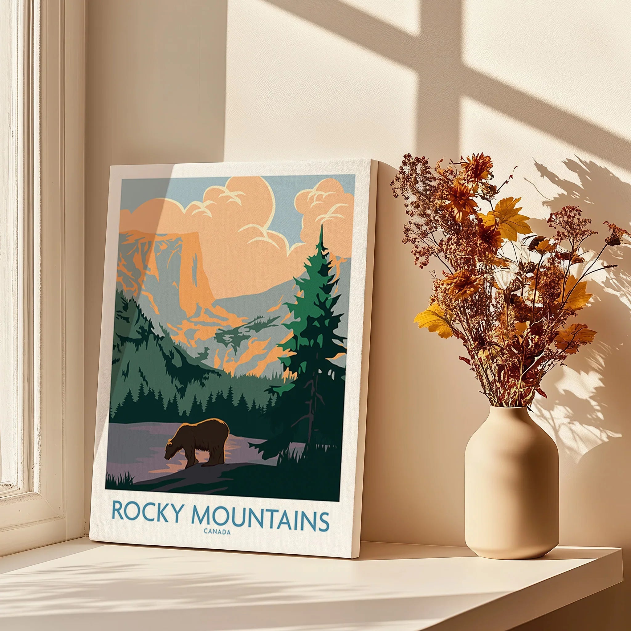 Rocky Mountains Canada canvas print with bear and forest, beside vase of dried flowers on sunlit table