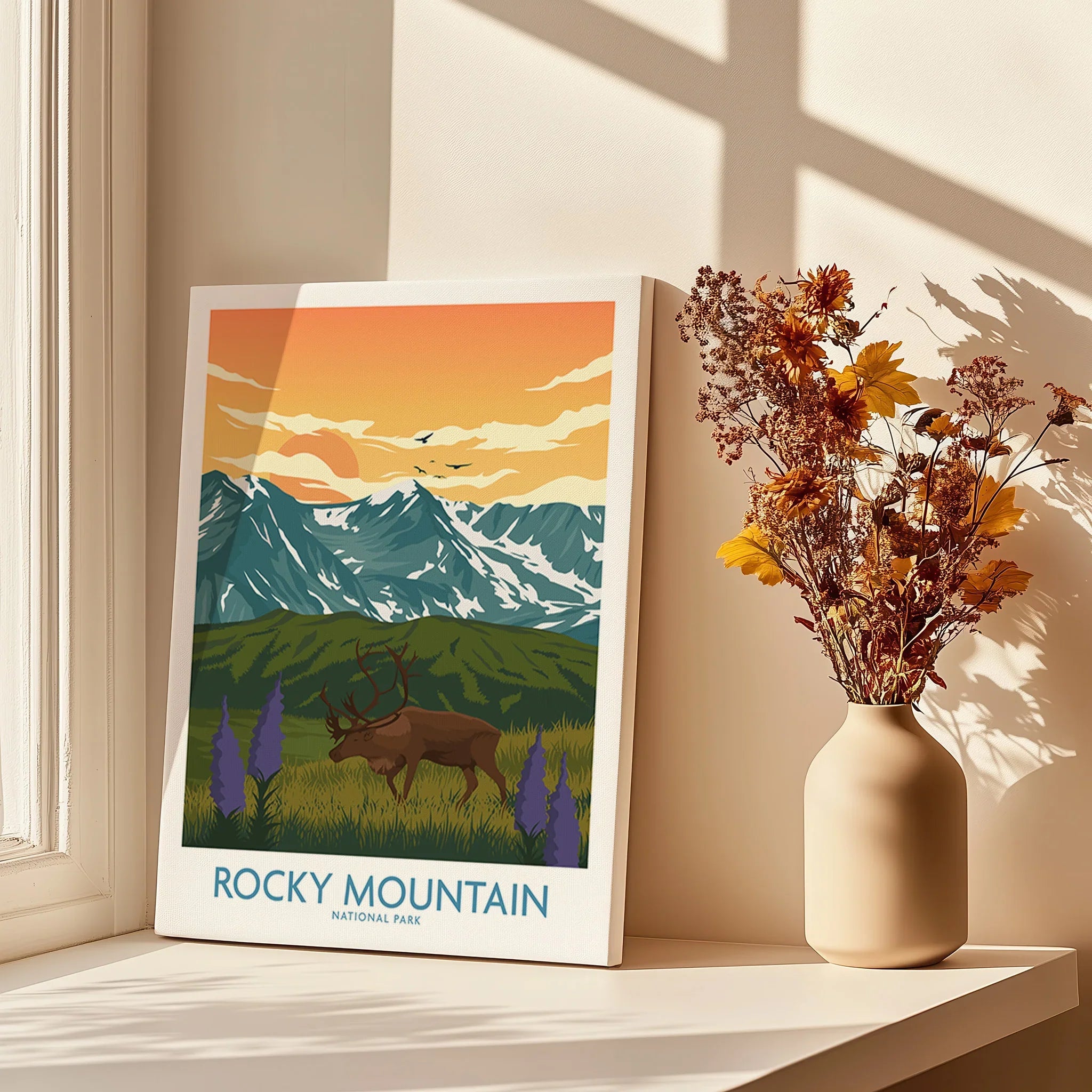 Rocky Mountain National Park wall art print with elk, mountains and sunset, styled on a windowsill with a vase of dried flowers.