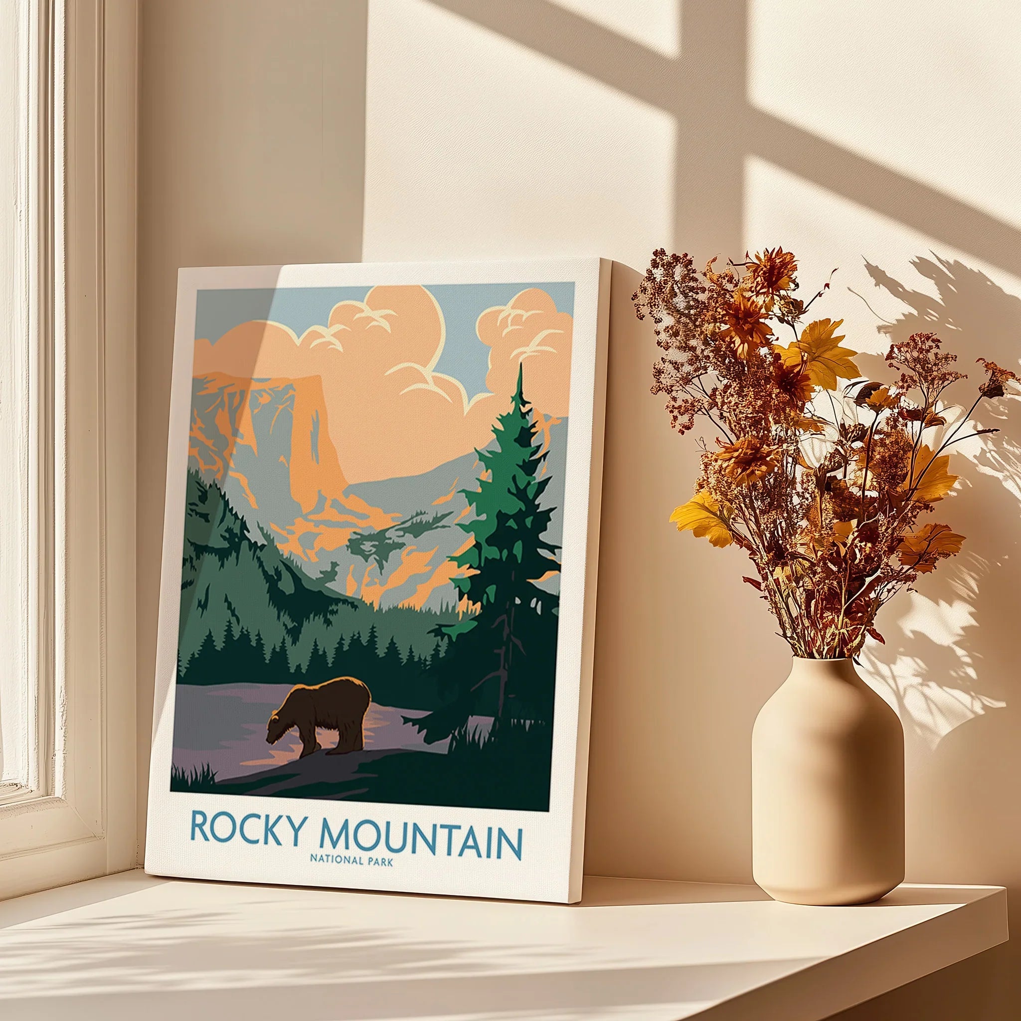 Rocky Mountain National Park art print on windowsill with vase of dried flowers in sunlight