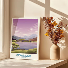 Snowdonia National Park canvas print with purple landscape by a sunlit window and vase of dried flowers