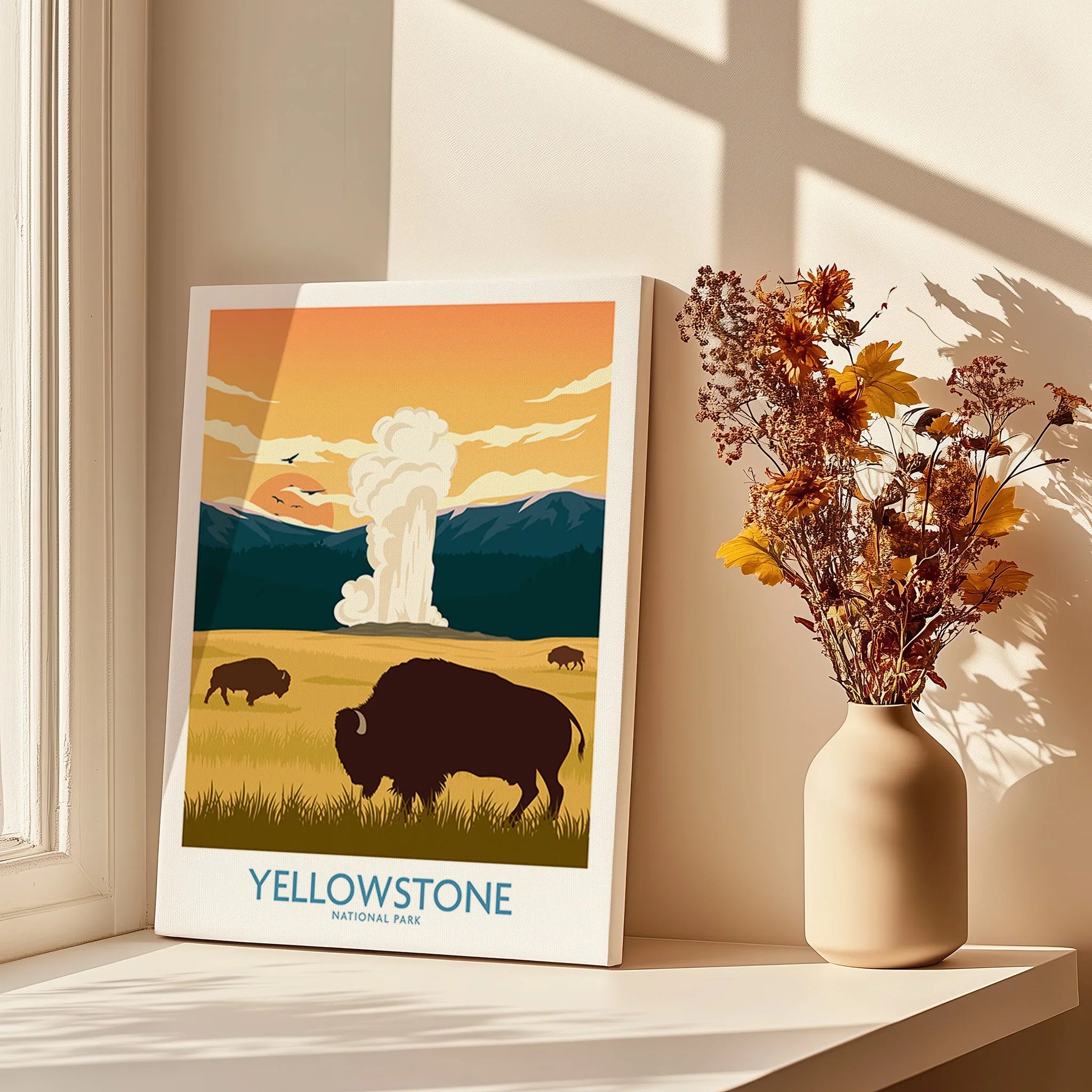 Yellowstone National Park print with bison and geyser on windowsill beside flower vase
