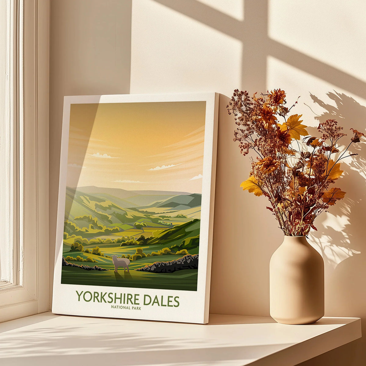 Yorkshire Dales National Park art print with rolling hills, next to a vase of dried flowers in sunlight