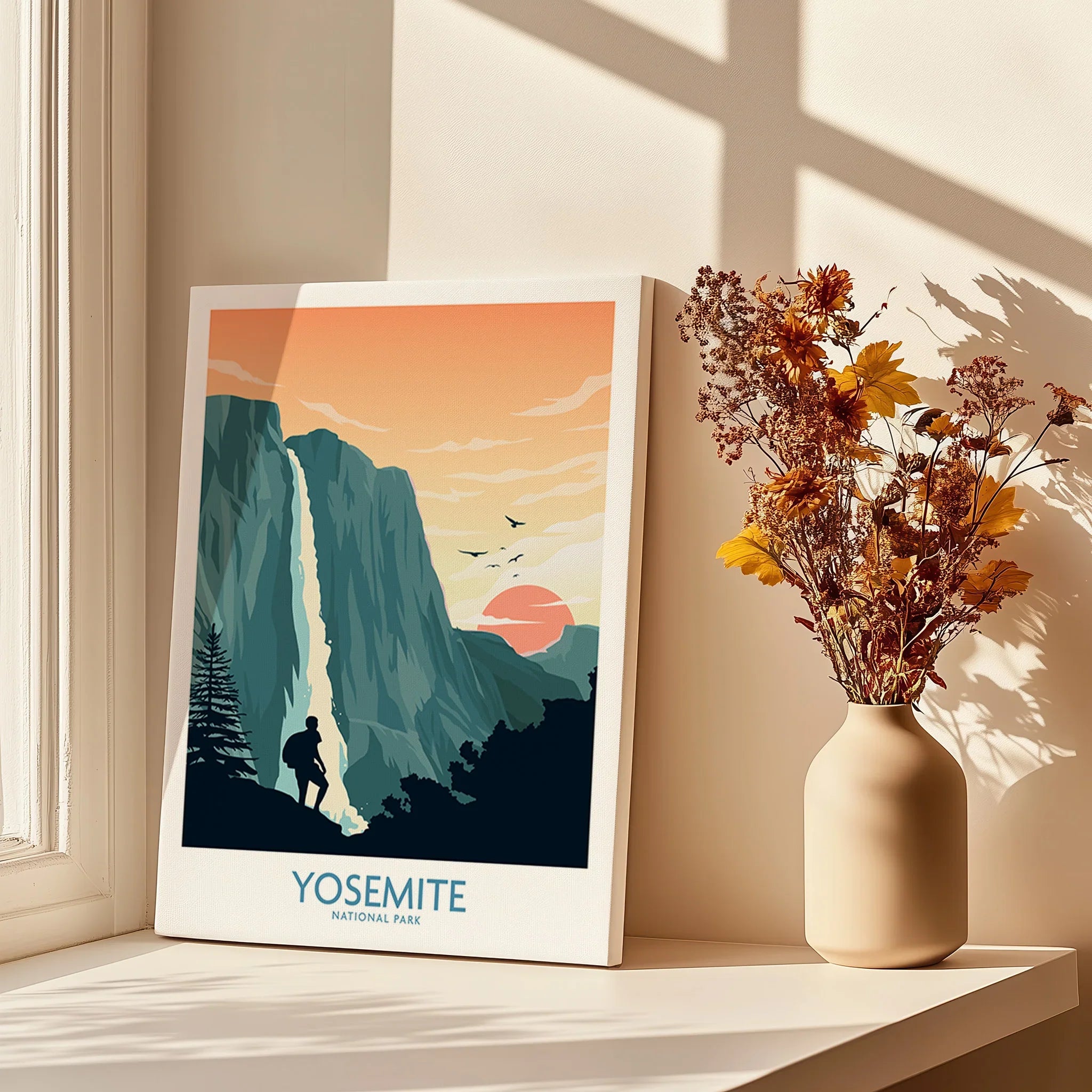 Yosemite National Park canvas print with waterfall and hiker, next to vase of dried flowers on windowsill