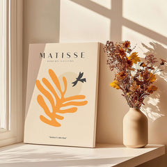 Matisse Art Prints - Orange Leaf Bird Silhouette Poster displayed next to flowers in a vase.