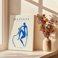 Matisse Art Prints -  Blue Nude Seated Figure Poster displayed with flowers in vase, showcasing minimalist modern art style.