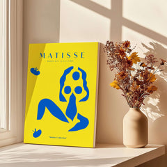 Matisse Art Prints - Blue Nude Abstract Figure Yellow Poster displayed in a bright room with flowers.