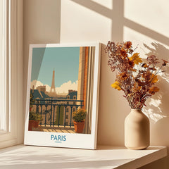 Paris travel poster art print on a windowsill with autumn flowers in a vase and soft shadows.