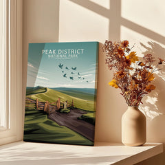 Peak District National Park travel poster canvas with scenic countryside, beside vase of dried flowers
