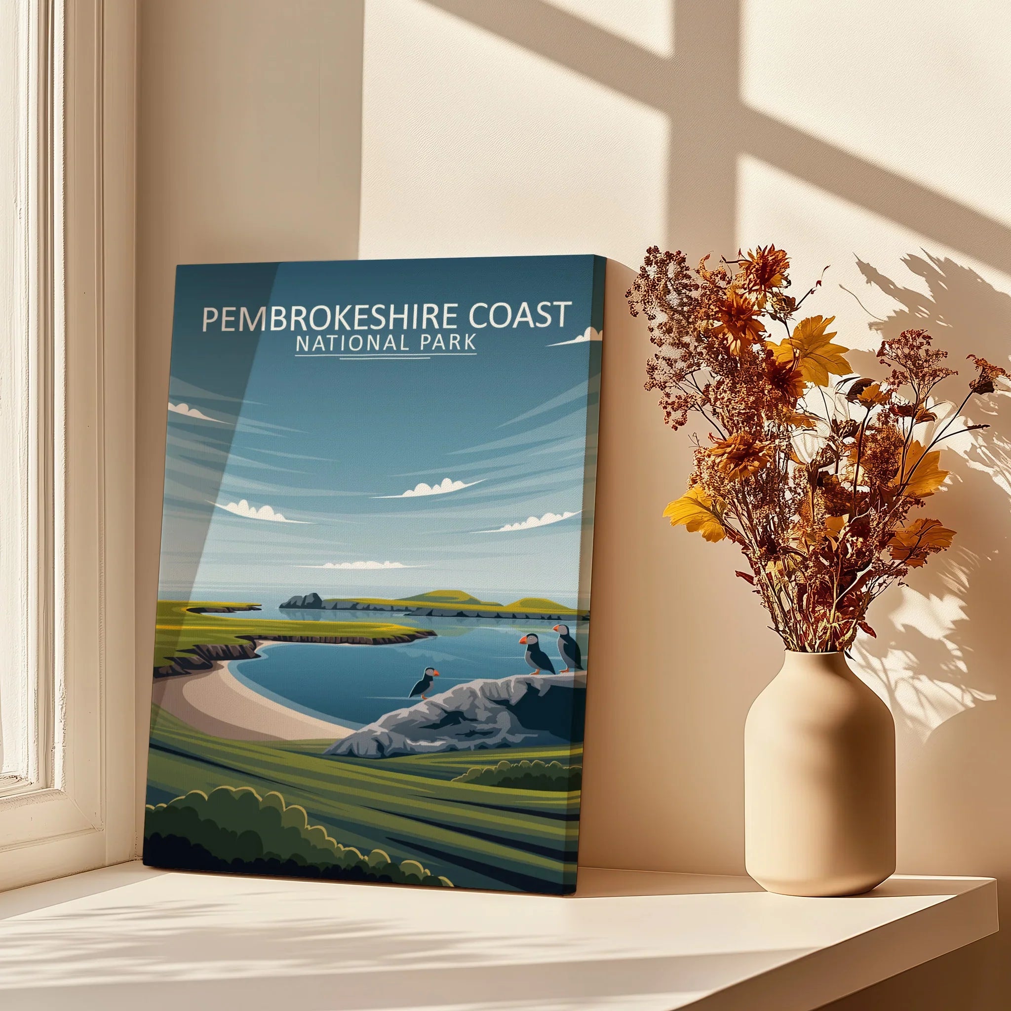 Pembrokeshire Coast National Park print on windowsill with vase of dried flowers, sunlight and shadows
