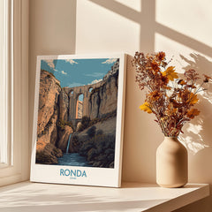 Ronda Spain Poster | Dramatic Andalusian Mountain Bridge Canvas Print showcased in a cozy interior with flowers.