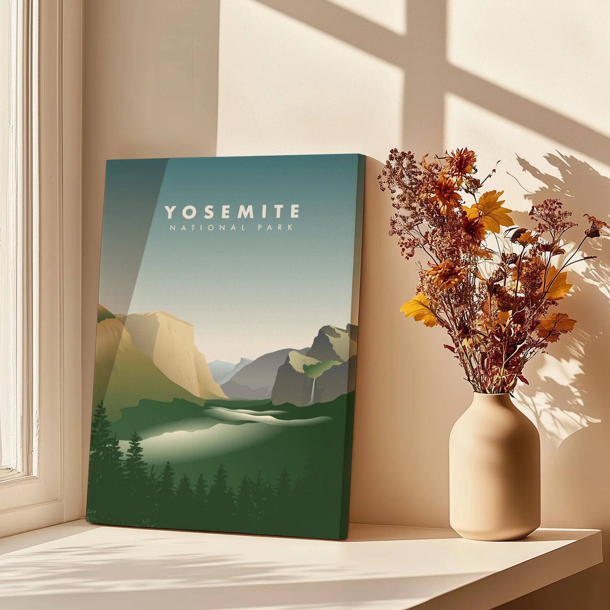 Yosemite National Park canvas print in sunlight beside a vase of dried flowers on a windowsill.