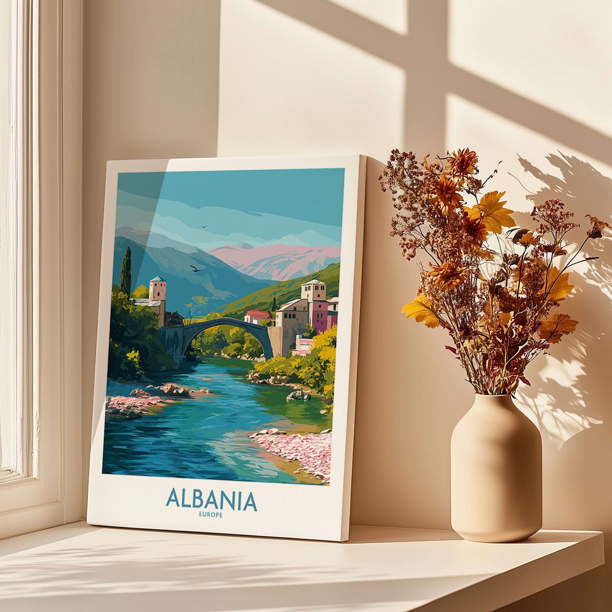 Albania Historic Stone Bridge Art Print | Mountain River Landscape Poster displayed by a window with flowers.
