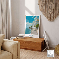 Trieste Print Italy Seafront Poster displayed in a cozy living room with a stylish wooden bench and decor.