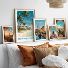 Framed travel posters of Anna Maria Island, Paris, Copenhagen, Tokyo, and Barcelona above a bed