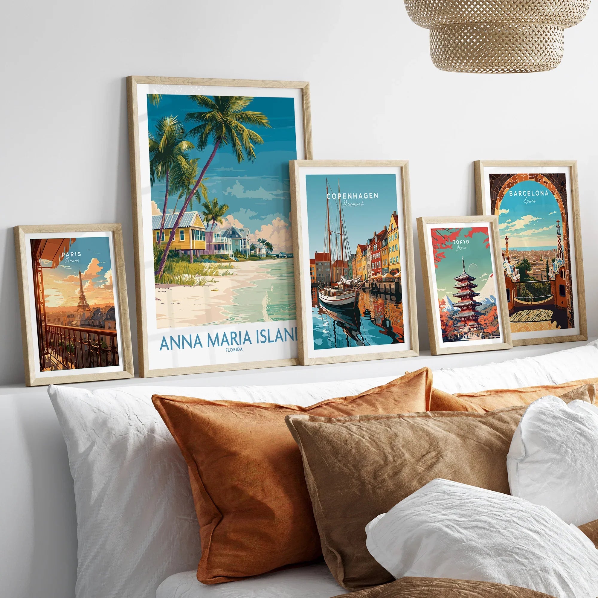 Framed travel posters of Anna Maria Island, Paris, Copenhagen, Tokyo, and Barcelona above a bed