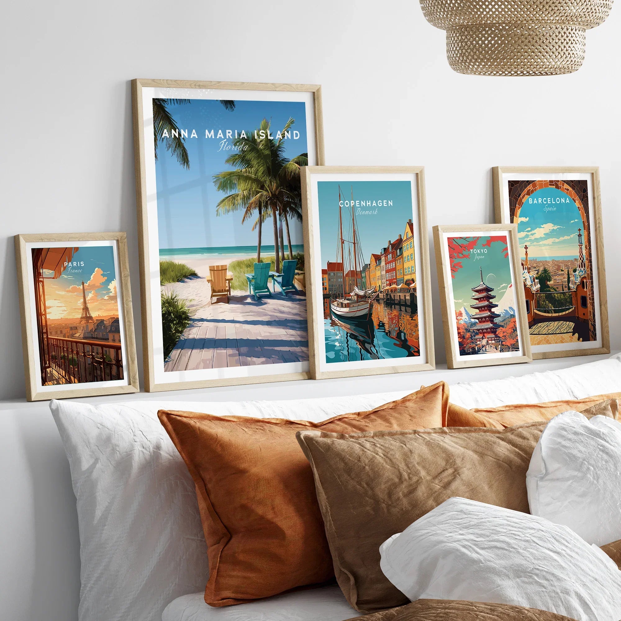 Framed travel art prints of Paris, Anna Maria Island, Copenhagen, Tokyo, and Barcelona above a bed