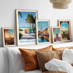 Framed travel and city skyline art prints above bed, featuring Paris, Anna Maria Island, Copenhagen, Tokyo, and Barcelona.