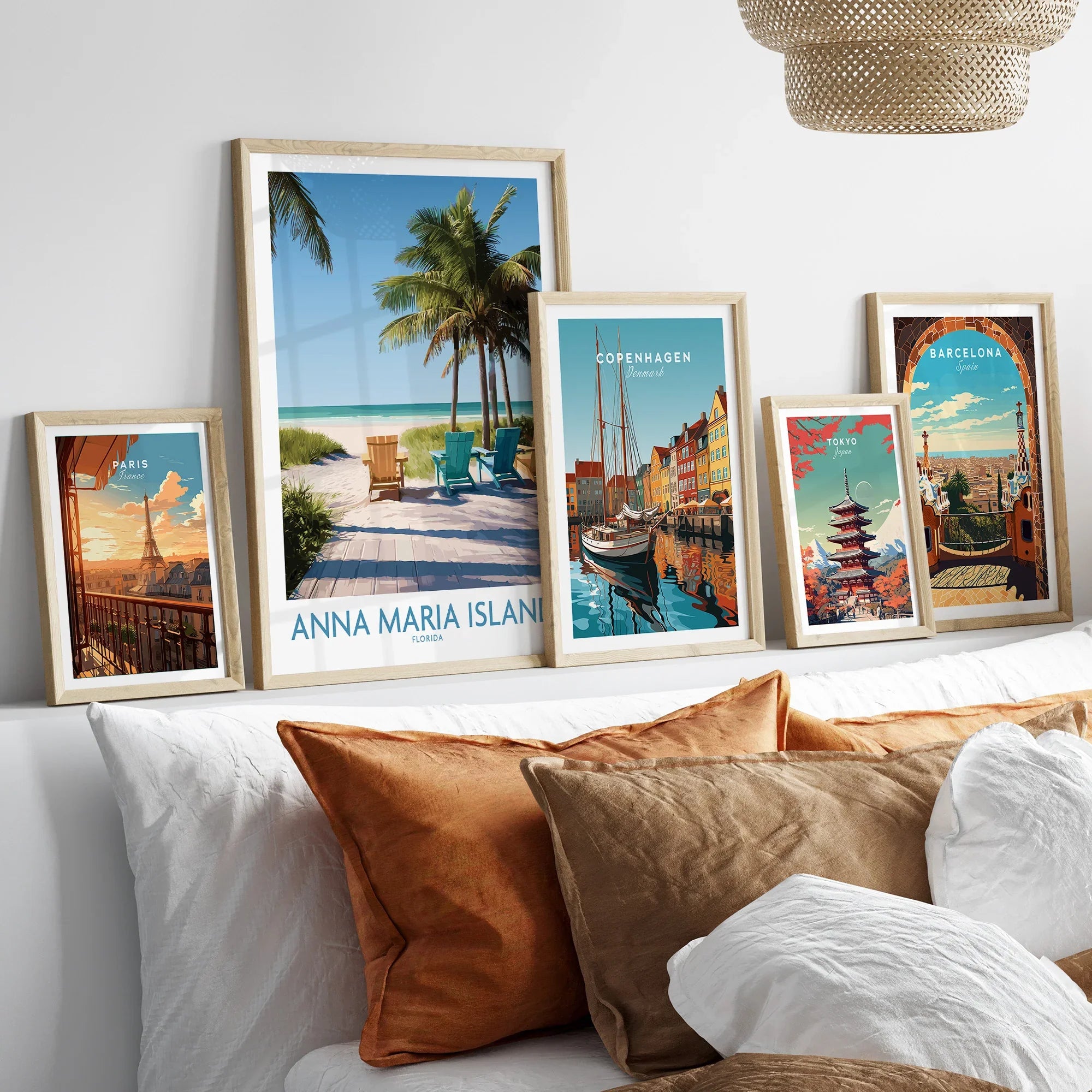Framed travel and city skyline art prints above bed, featuring Paris, Anna Maria Island, Copenhagen, Tokyo, and Barcelona.