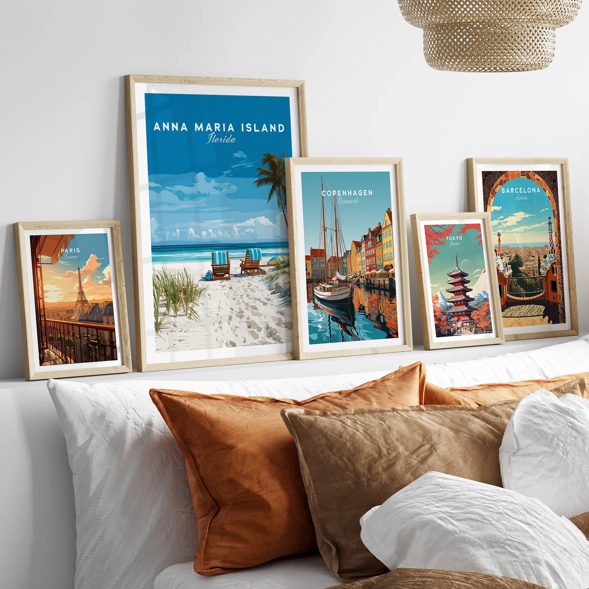 Framed travel posters of Paris, Anna Maria Island, Copenhagen, Tokyo, and Barcelona above a bed
