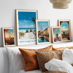 Framed travel poster prints of Anna Maria Island, Paris, Copenhagen, Tokyo, and Barcelona above a bed