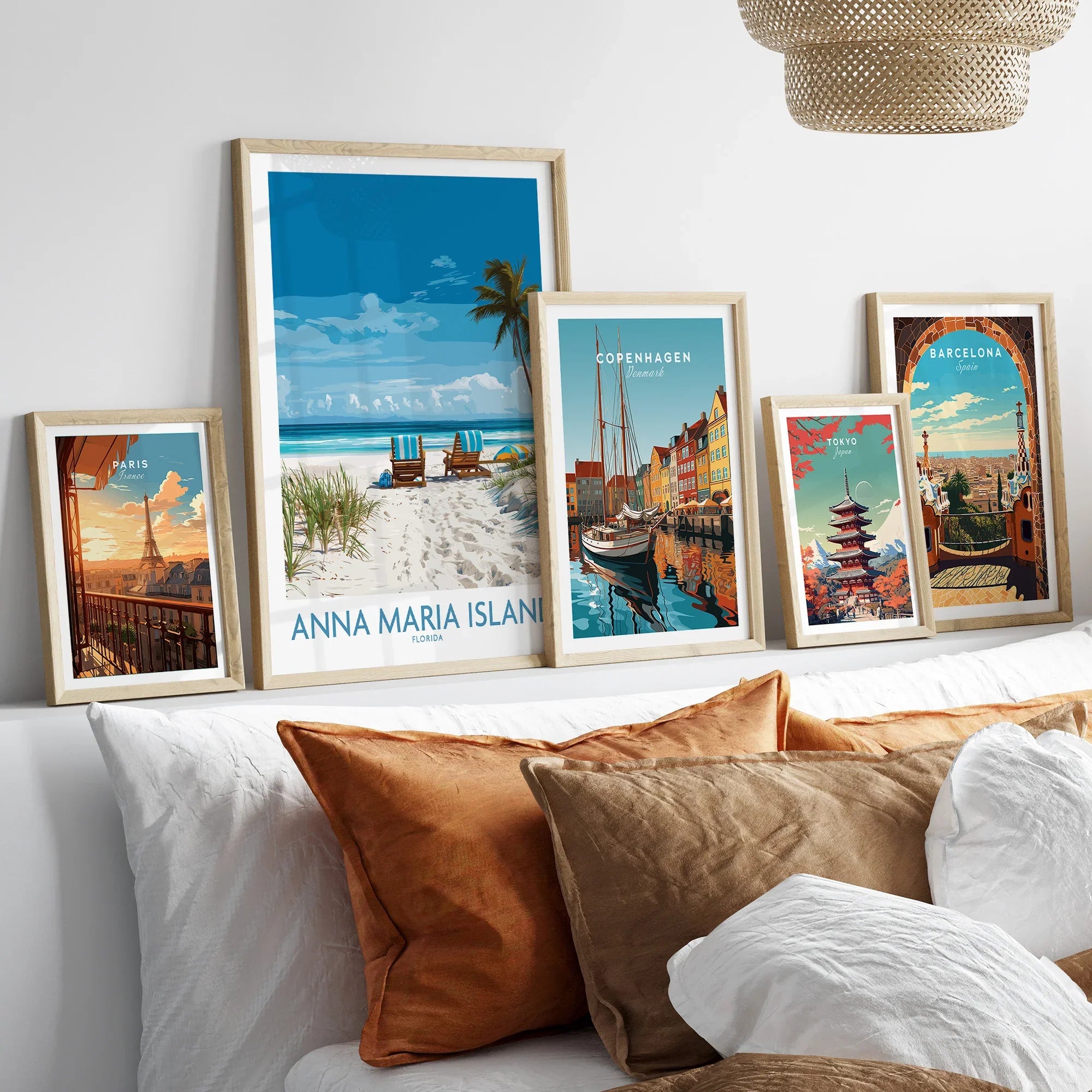 Framed travel poster prints of Anna Maria Island, Paris, Copenhagen, Tokyo, and Barcelona above a bed