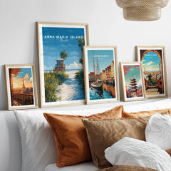 Framed travel posters of Anna Maria Island, Copenhagen, Paris, Tokyo, and Barcelona above a bed