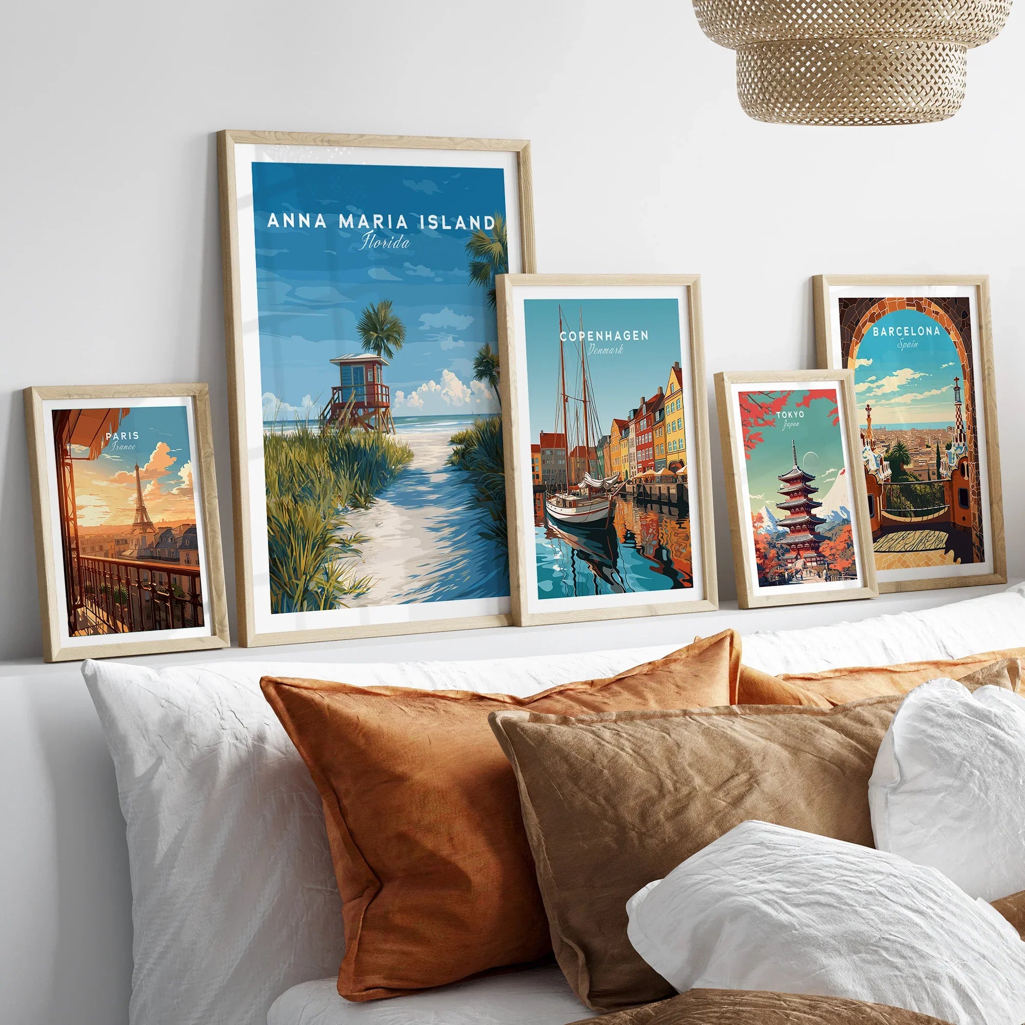 Framed travel posters of Anna Maria Island, Copenhagen, Paris, Tokyo, and Barcelona above a bed