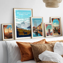 Set of five framed travel posters above bed featuring Paris, Aoraki, Copenhagen, Tokyo, Barcelona.