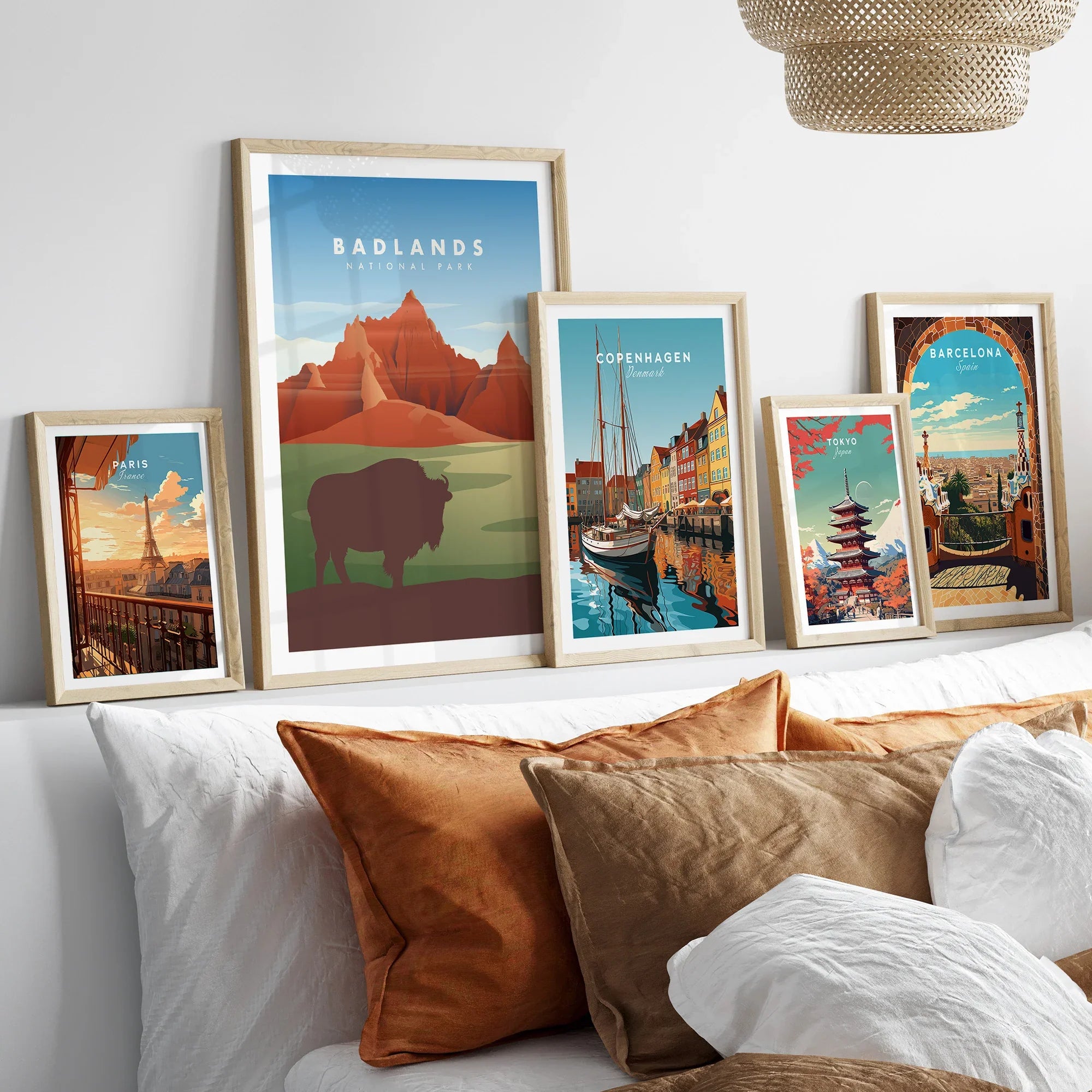 Set of five framed travel posters above bed, featuring Badlands, Paris, Copenhagen, Tokyo, and Barcelona.
