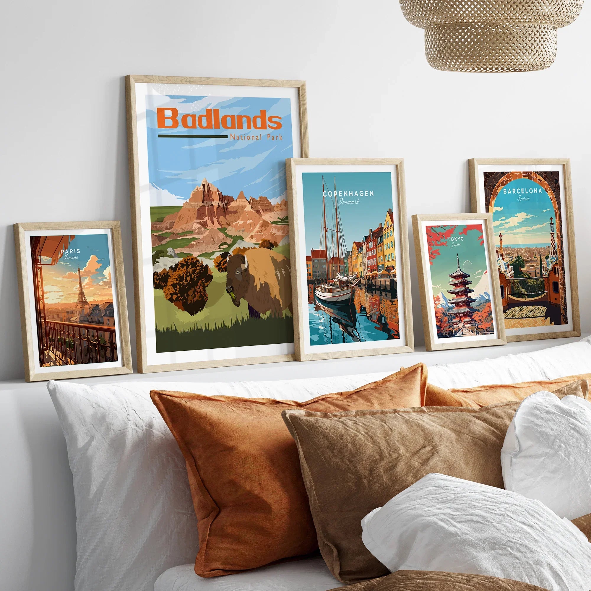 Set of five framed travel and national park art prints above bed, natural wood frames, cozy decor.