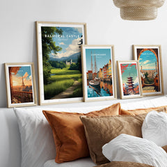 Set of five framed travel posters featuring city skylines and landmarks above a bed