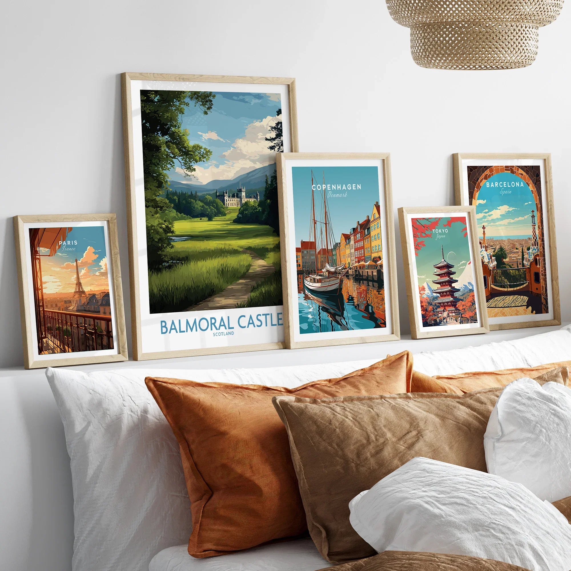 Framed travel art prints of Paris, Balmoral Castle, Copenhagen, Tokyo, and Barcelona above bed