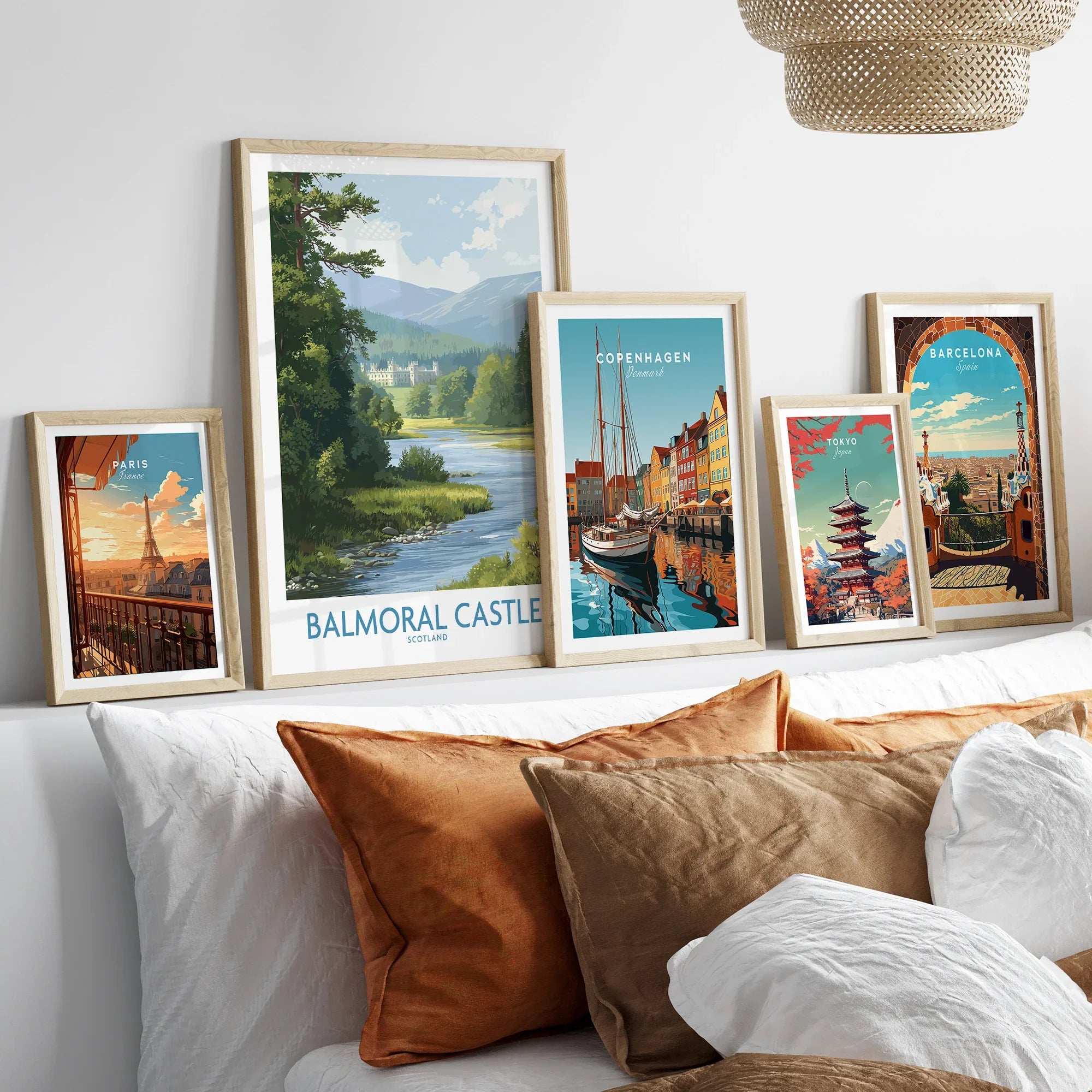 Set of five framed travel posters featuring city skylines and landmarks above a bed