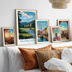 Framed travel city skyline art prints above bed with white and brown pillows.