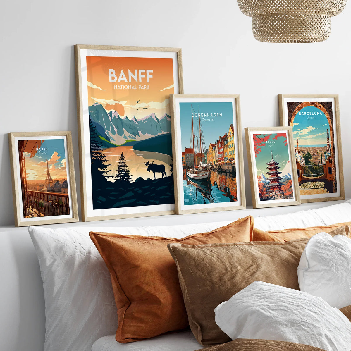 Set of five framed travel posters above bed, featuring Banff National Park, Paris, Copenhagen, Tokyo, and Barcelona.