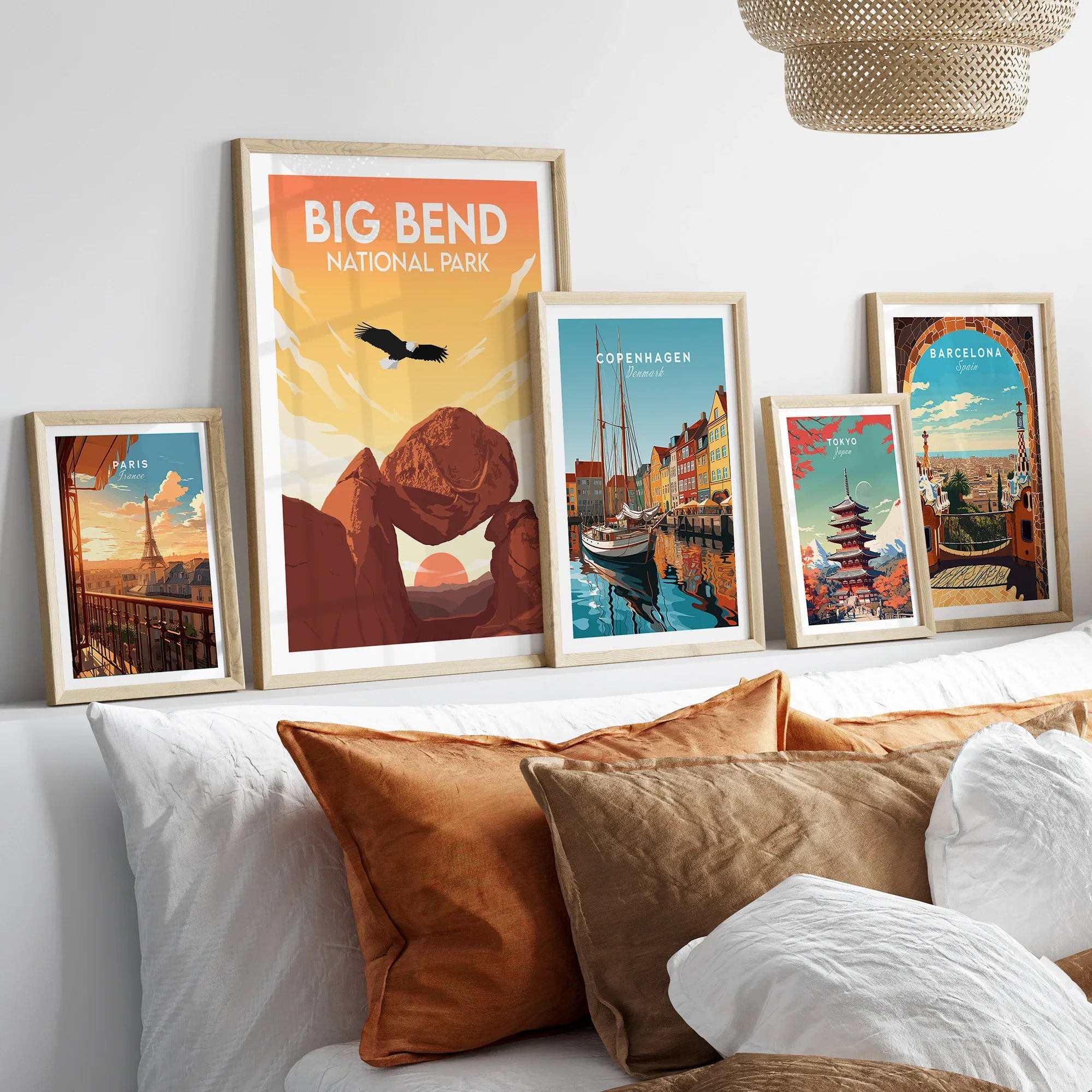 Set of five framed travel posters above bed, featuring national park and city wall art.