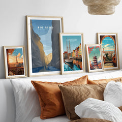 Set of five framed travel posters above bed, featuring Paris, Big Bend, Copenhagen, Tokyo, Barcelona.