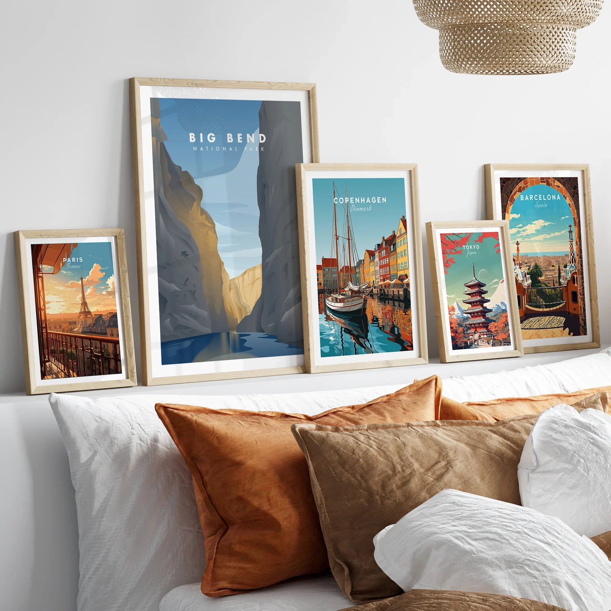 Set of five framed travel posters above bed, featuring Paris, Big Bend, Copenhagen, Tokyo, Barcelona.