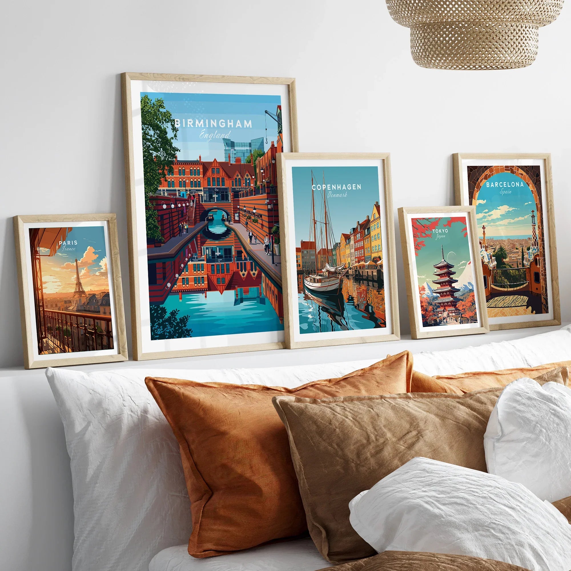 Framed travel posters of Paris, Birmingham, Copenhagen, Tokyo, and Barcelona above a bed