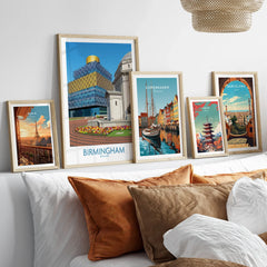 Framed travel posters of Birmingham, Paris, Copenhagen, Tokyo, and Barcelona above a bed