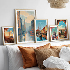 Framed travel posters of Birmingham, Copenhagen, Paris, Tokyo, and Barcelona above a bed